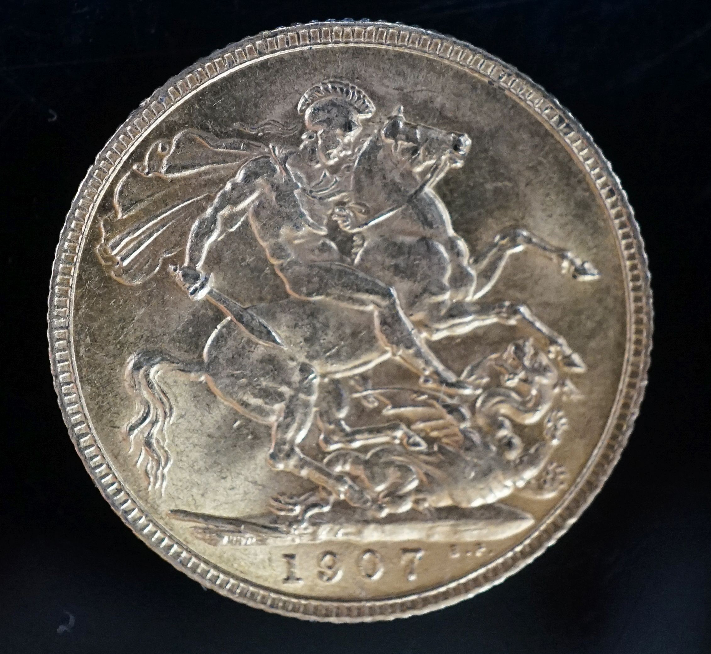 A late Victorian 9ct gold sovereign case with engraved monogram, containing an Edward VII 1907 gold sovereign, gross weight 24.2 grams.
